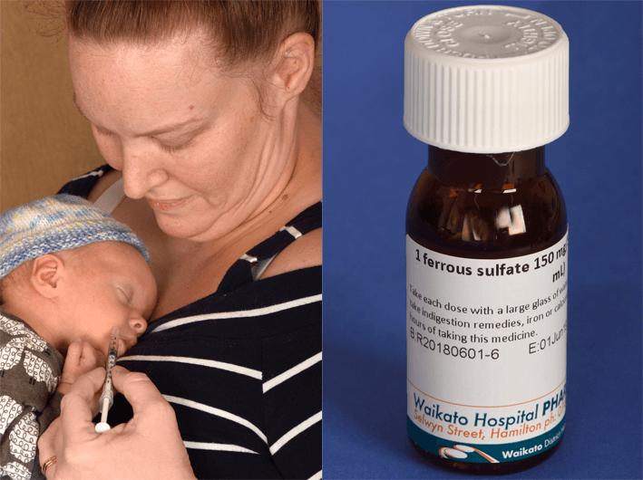 A mother giving iron to her baby and a bottle of iron