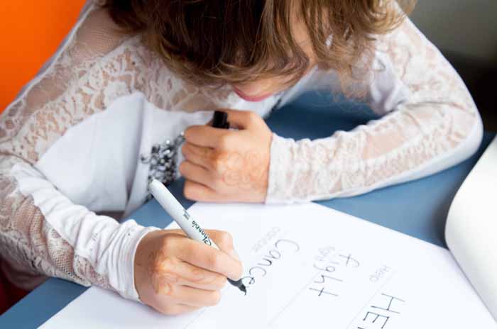 A young girl writing at a desk