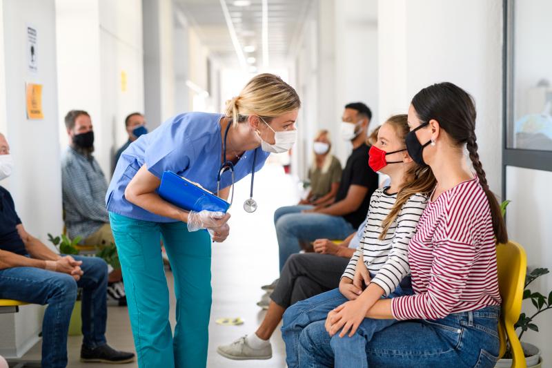 Photo of a doctor speaking to a mum and daughter in the clinic waiting room 