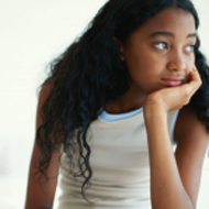 A young girl resting her head in her hand