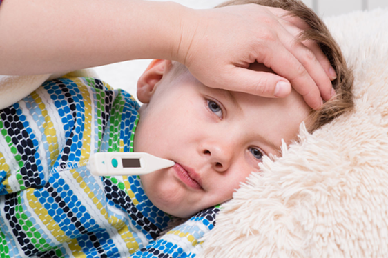 A boy with a themometer in his mouth