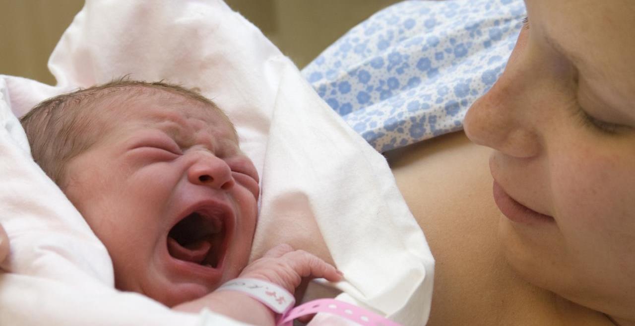 Crying baby in mother's arms