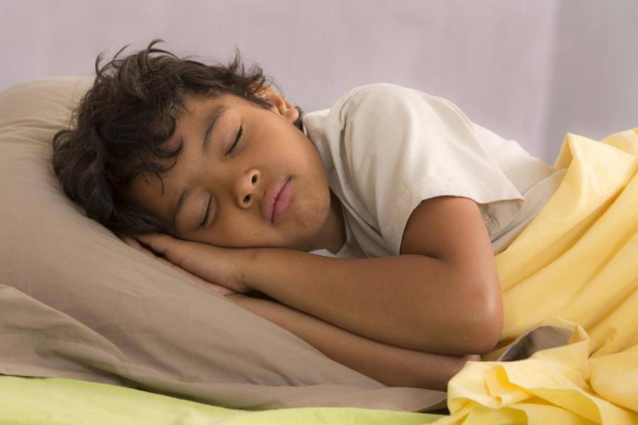 Young boy asleep in bed