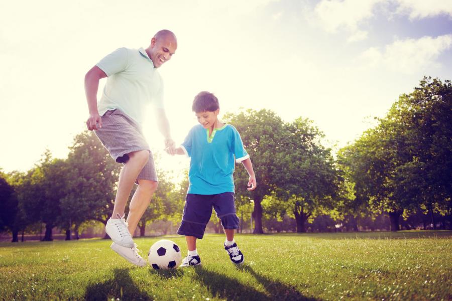 Father playing soccer with his son