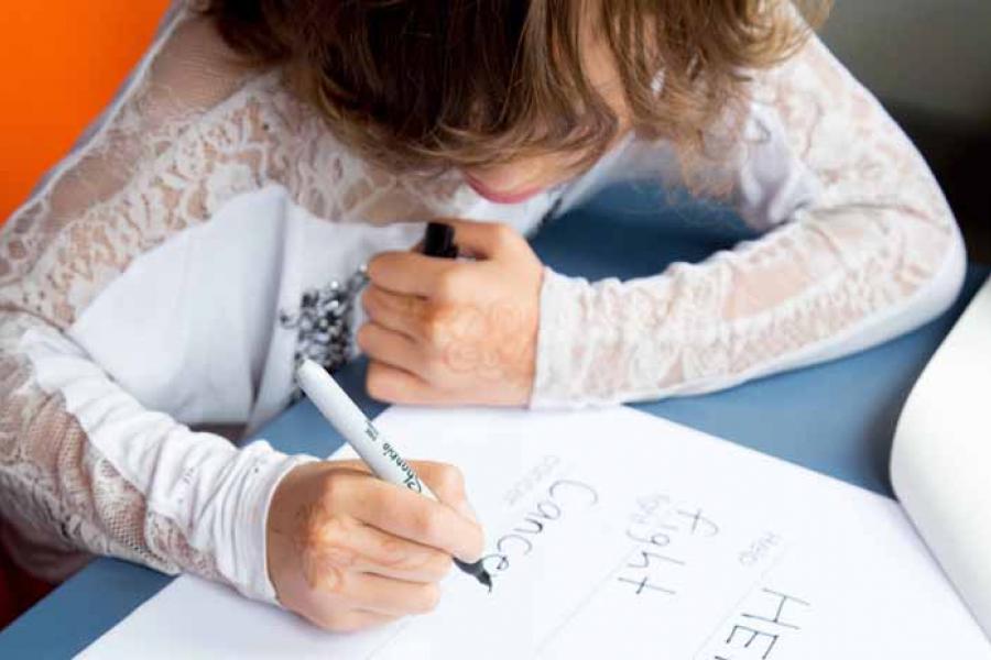 A girl sitting at a desk and writing