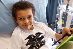 Child in hospital bed doing schoolwork