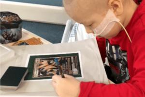 Child in hospital bed doing schoolwork