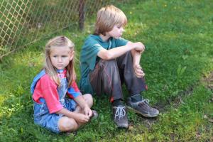 two siblings sitting on the grass