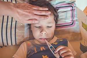 Boy lying down with thermometer in mouth