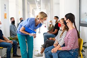 Health care professional talking to young seated patients