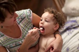 Mother brushing young child's teeth 