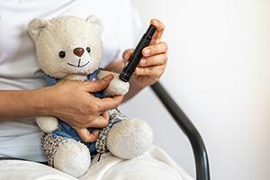 A teddy bear having a finger prick test 