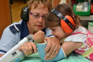 A nurse removing a child's arm plaster cast